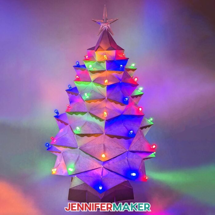 Learn how to make a light-up tabletop Christmas tree for the holidays with JenniferMaker's tutorial! An elaborate white cardstock Christmas tree glows with multicolored lights.