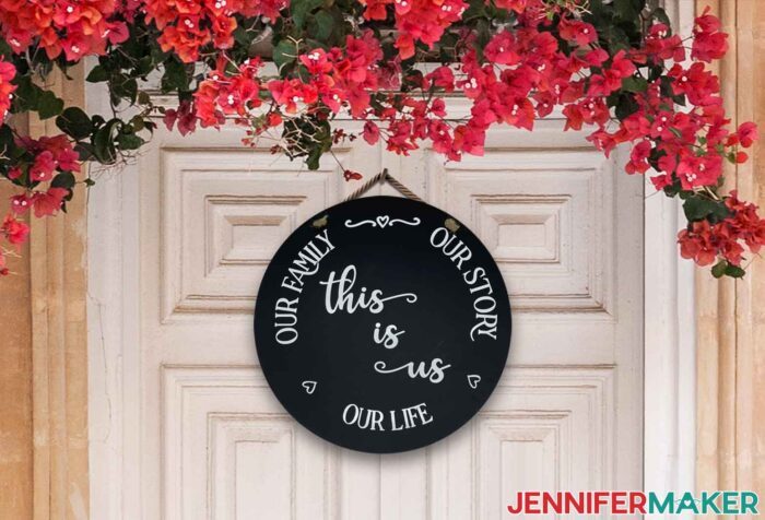 Round black sign from Target Dollar Spot DIYs with white decal saying Our family, Our story, Our life, this is us.