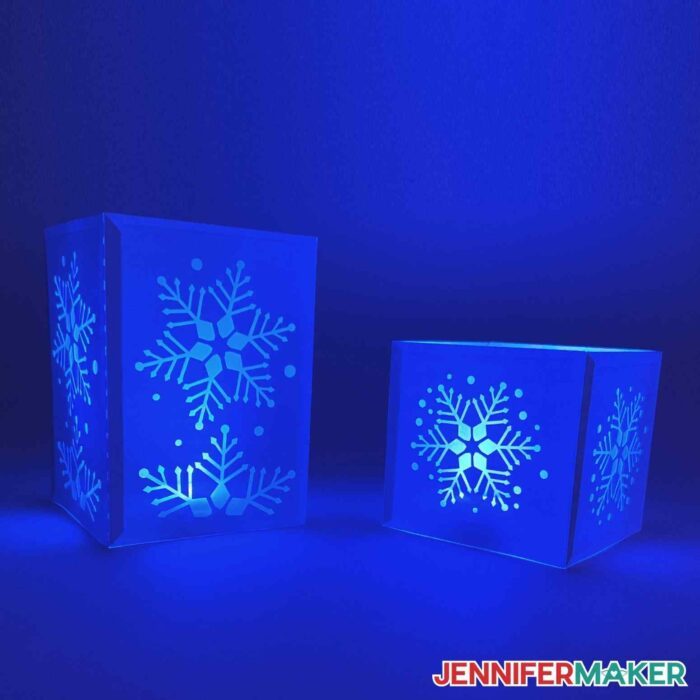 Two snowflake tea light holders illuminated with a blue light