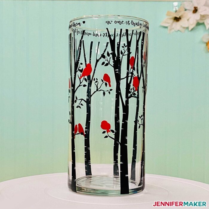 Glass vase with black trees and red cardinals made from a Dollar tree vase and Cricut vinyl