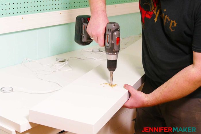 Drilling the hole into the shelf to install under shelf lighting cheap and easy