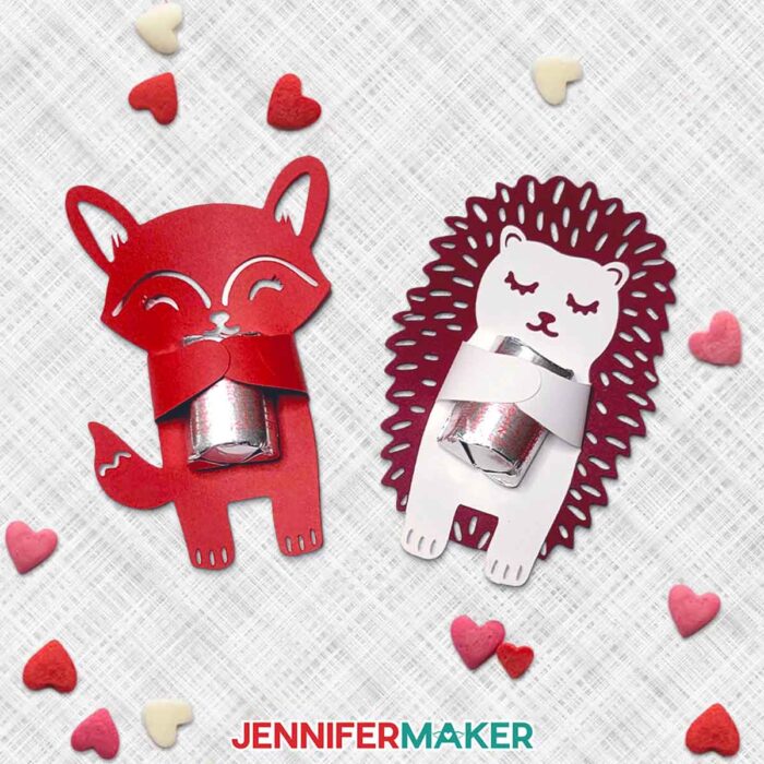 Cute animal candy huggers by JenniferMaker. A red cardstock fox and a dark red cardstock hedgehog each hug a wrapped chocolate candy.