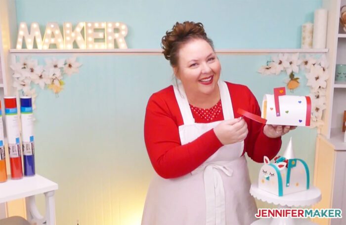 Jennifer Maker holding a paper Valentine Mailbox craft with a printable valentine inside