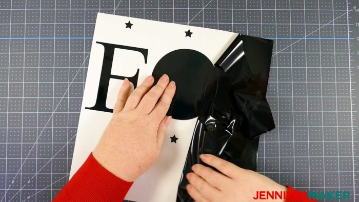 Weeding black vinyl to make a vertical welcome sign