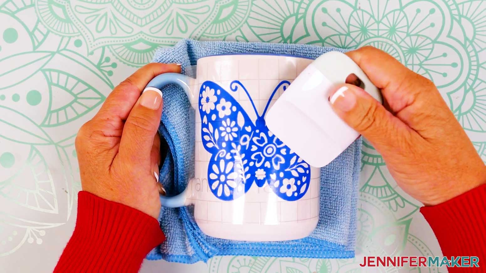 Use a scraper to burnish the butterfly vinyl vs iron on design onto the mug.
