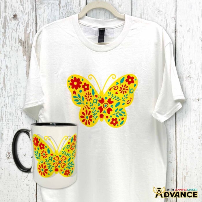 A white T-shirt and a white mug are decorated with the same multicolor butterfly design. Learn how to use Adhesive Vinyl Vs Iron-On For Cricut Beginners
