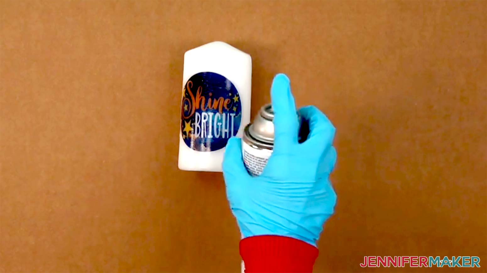 The finished dried candle is placed on a piece of card board and being spray with a clear coat to seal it.