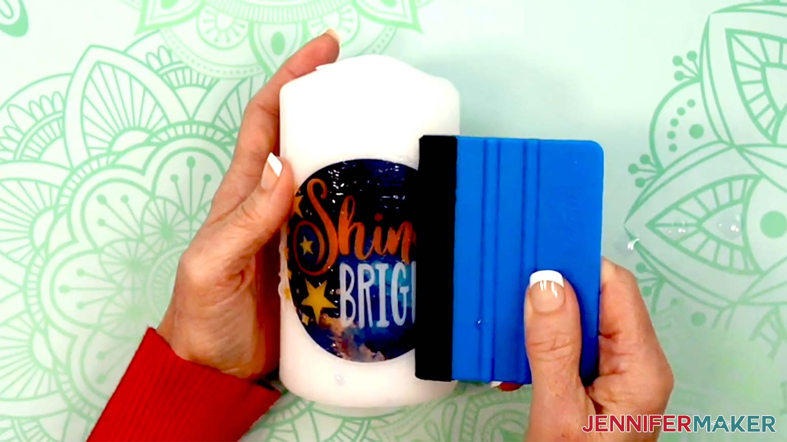 A felt tipped squeegee is being used to smooth out the second decal and remove excess water.