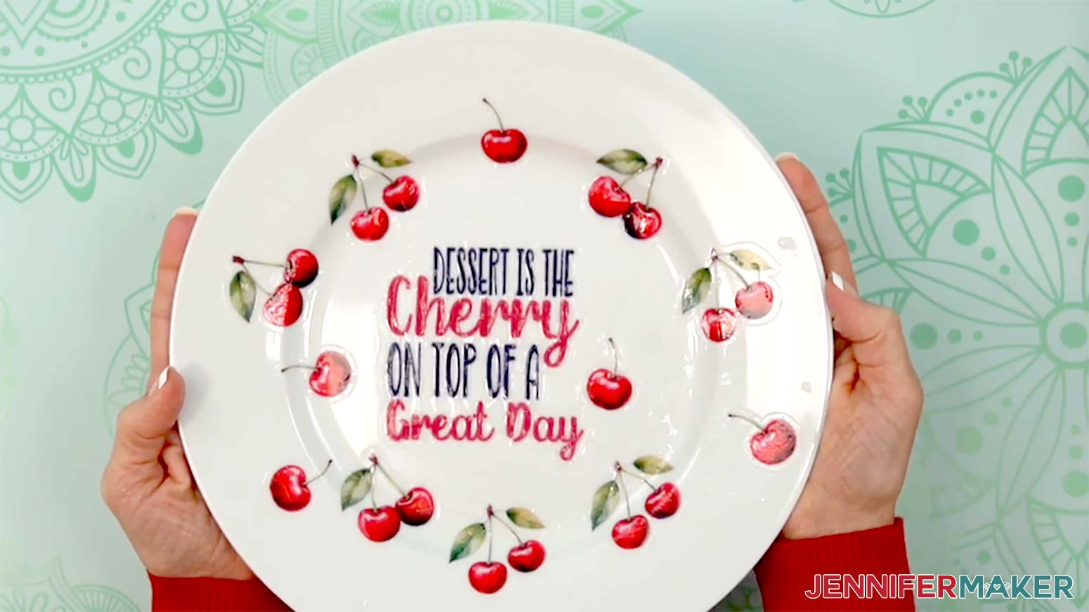 The finished cherry plate is being held up to show the finished product.