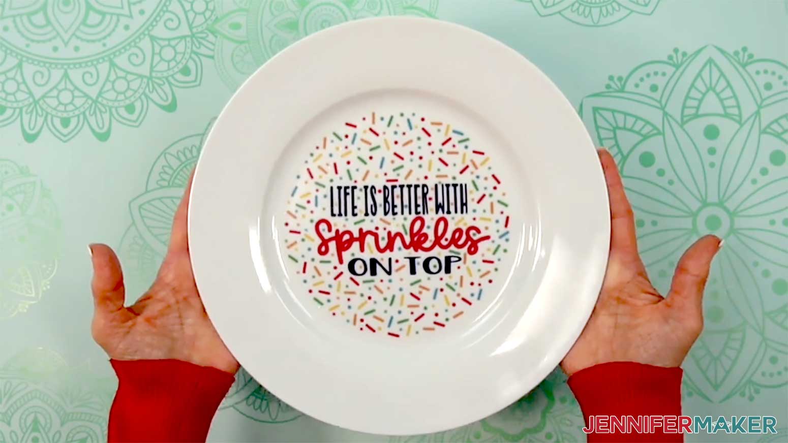 The finished waterslide decal sprinkle plate is held up to show the final product.