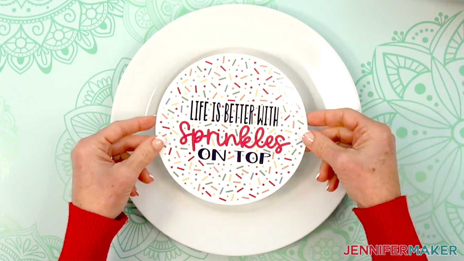 The sprinkles waterslide decal is being placed in the center of the plate to ensure it fits where it is intended to be placed.