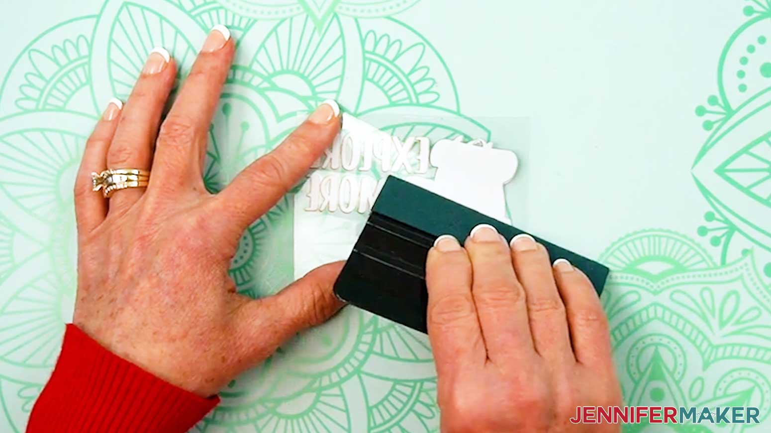 Use the squeegee to press the UV DTF design into the adhesive top carrier sheet.