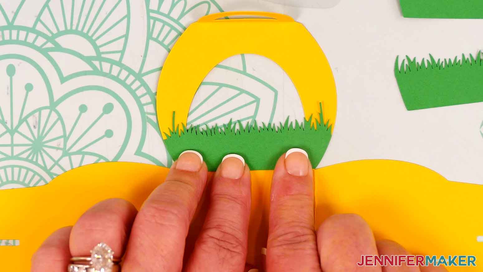 Press the grass piece to the treat box to adhere it to the treat box.