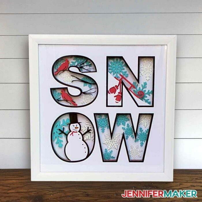 Winter shadow box with the word "SNOW" and seasonal decor inside the letters