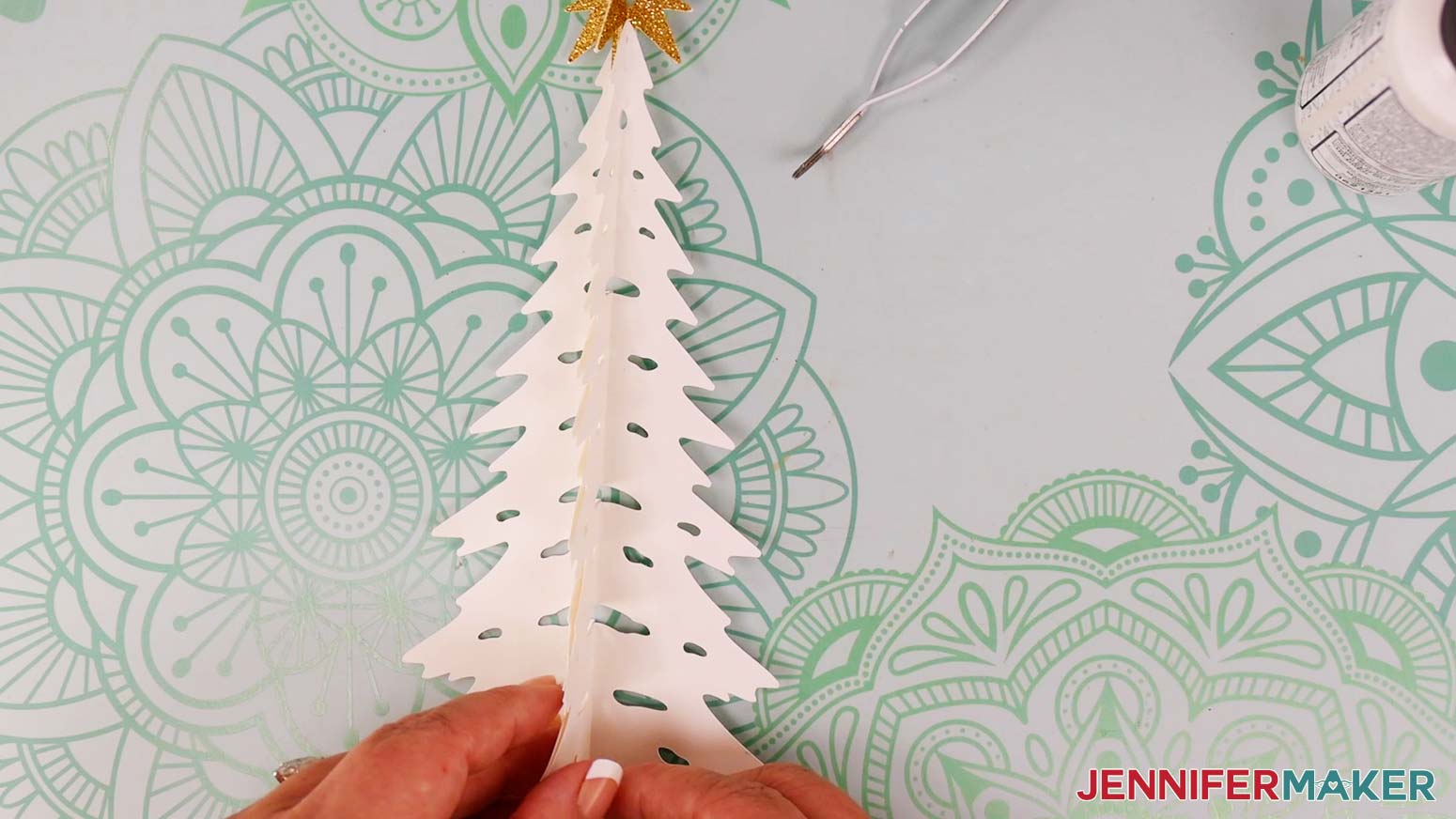 Attach the glued section to the first tree piece on the same side as the attached star, aligning the tree halves at their edges