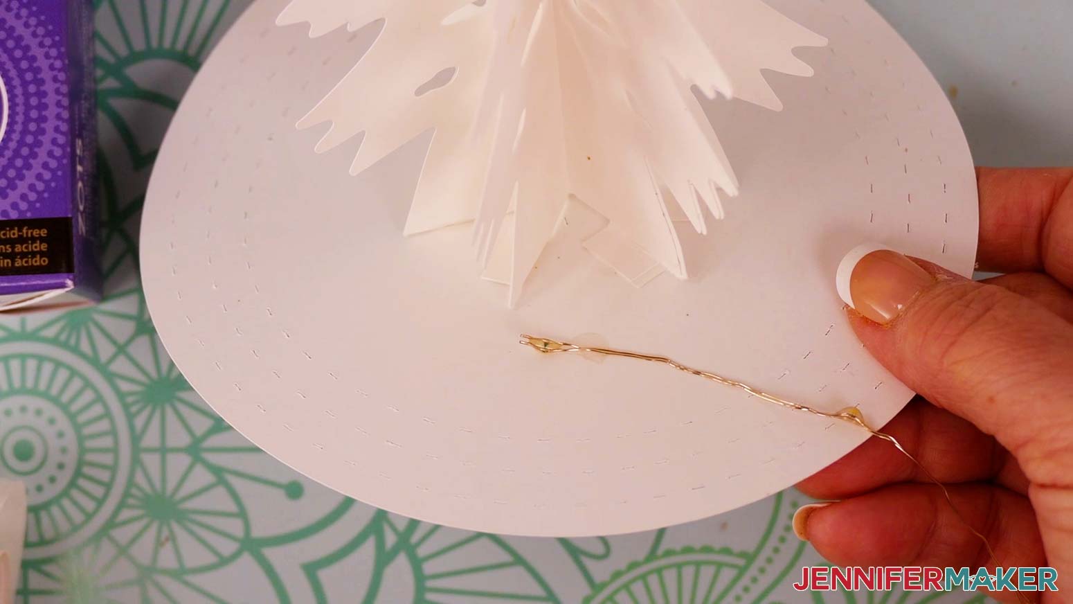 Starting at the free end of the fairy lights, place the lights on the circular base around the outside of the attached tree