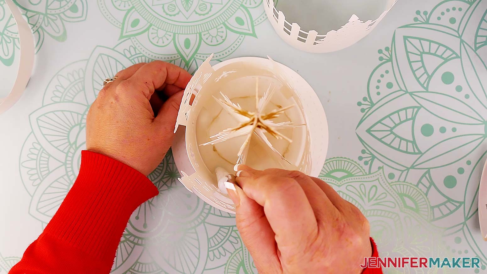 Use a thin object with a blunt end, like the handle end of your spatula or weeding tool, to press the glued tabs down.