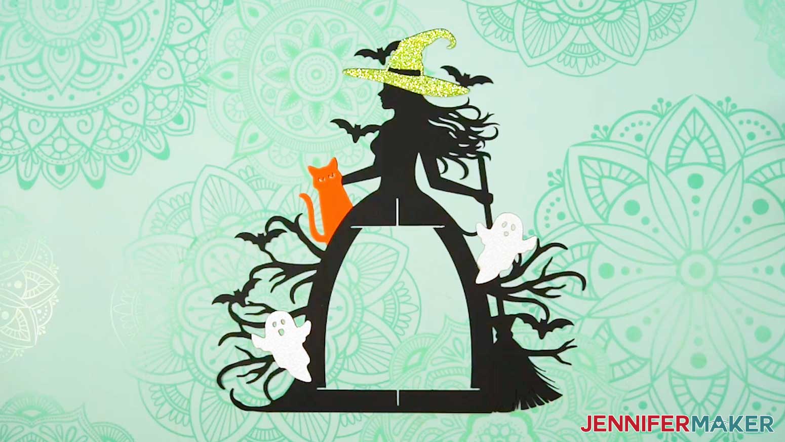 The hat, cat, and two ghost elements glued to the front of the witch lantern frame.